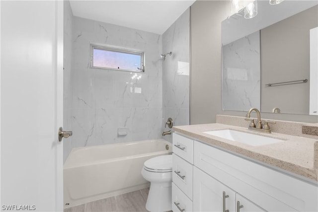 full bathroom featuring toilet, vanity, and tiled shower / bath combo