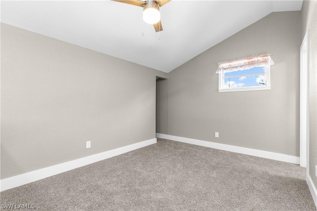 carpeted spare room featuring vaulted ceiling and ceiling fan