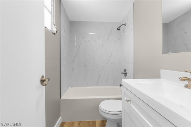 full bathroom with vanity, tiled shower / bath, toilet, and hardwood / wood-style floors