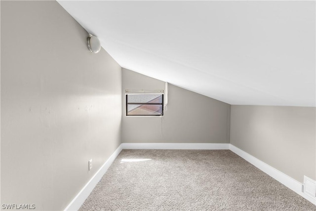 bonus room with vaulted ceiling and carpet floors