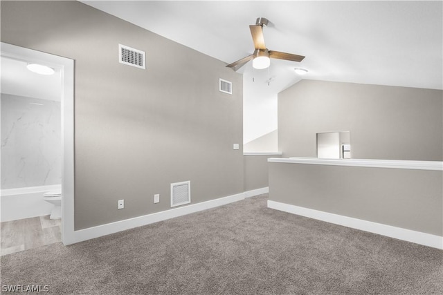 carpeted spare room with vaulted ceiling and ceiling fan