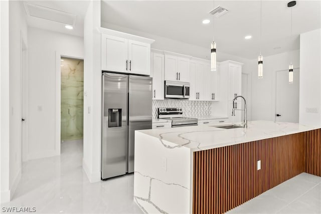 kitchen featuring stainless steel appliances, hanging light fixtures, and white cabinets