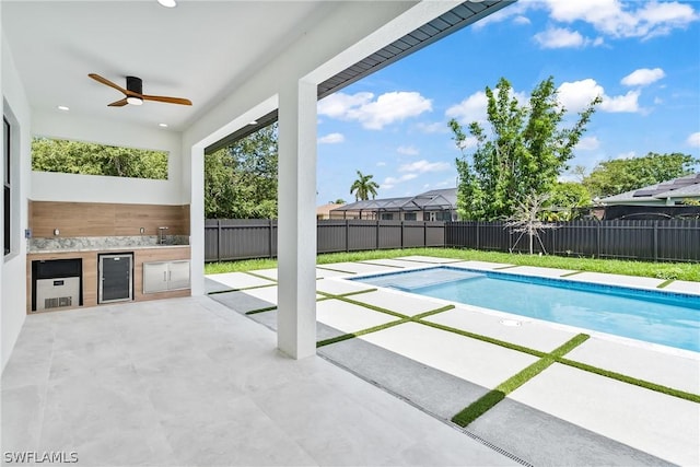 view of swimming pool with ceiling fan, area for grilling, and a patio