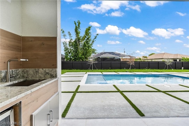 view of swimming pool featuring sink and a patio