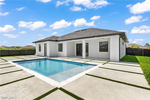 rear view of house featuring a fenced in pool and a patio area