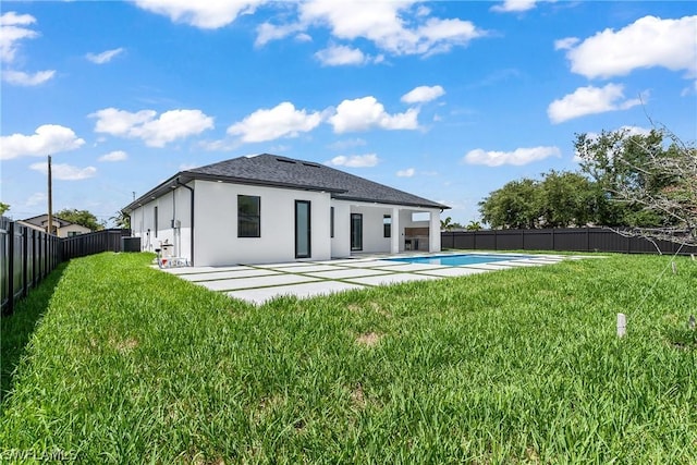 back of house featuring a yard, a fenced in pool, and a patio