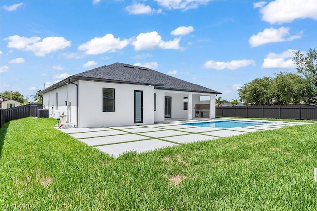 rear view of house with a fenced in pool, central AC unit, a lawn, and a patio area