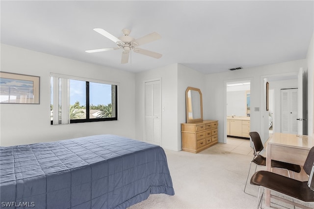 bedroom featuring connected bathroom, ceiling fan, a closet, and light carpet