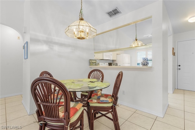 tiled dining room with a chandelier