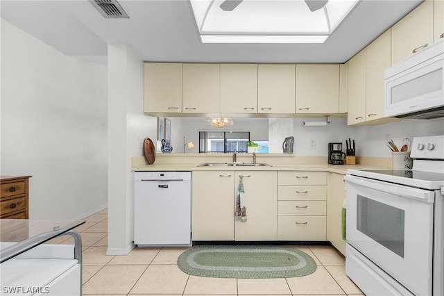 kitchen featuring white appliances, sink, an inviting chandelier, cream cabinetry, and light tile patterned flooring