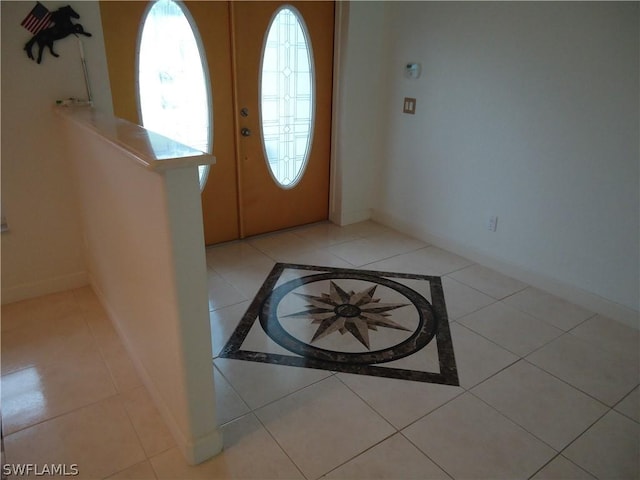 entrance foyer featuring light tile patterned floors, baseboards, and french doors