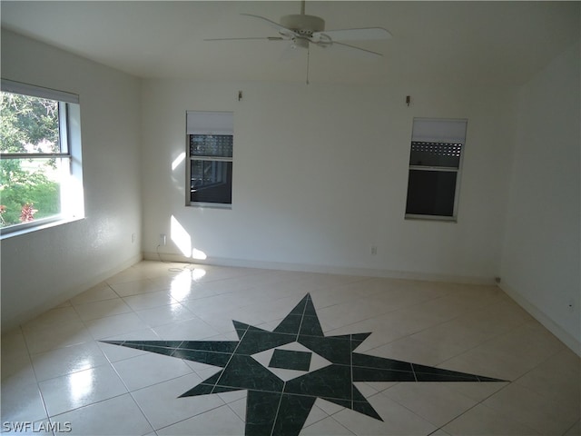 spare room featuring ceiling fan and light tile patterned flooring