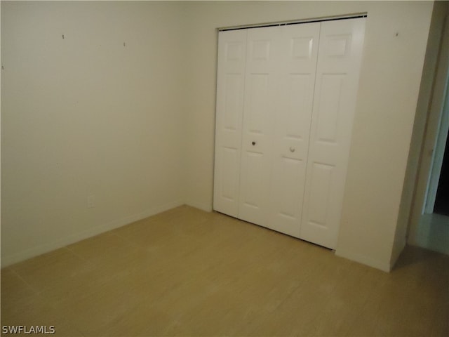 unfurnished bedroom with a closet and light hardwood / wood-style flooring