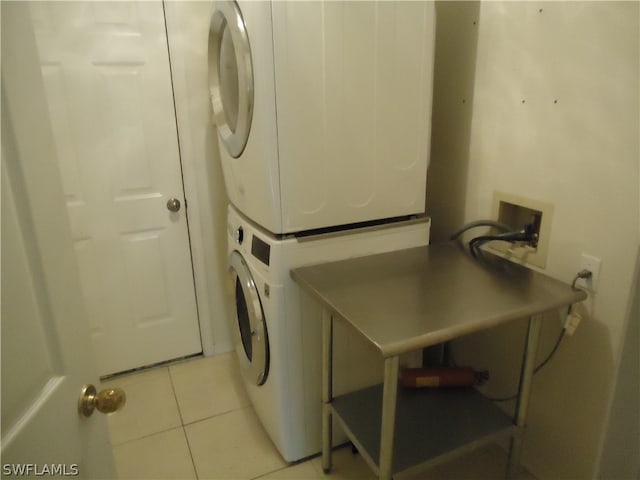 washroom featuring light tile patterned floors and stacked washer / drying machine