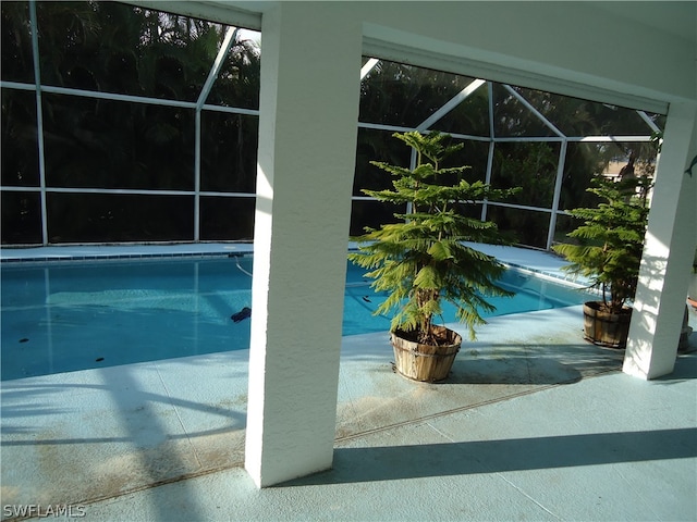 view of swimming pool with glass enclosure and a patio area