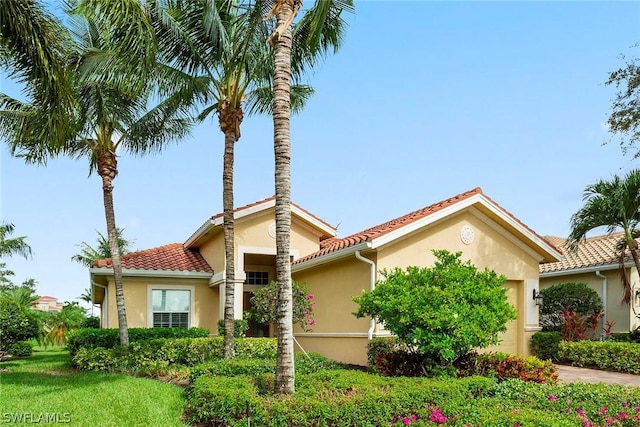 mediterranean / spanish home with a front yard