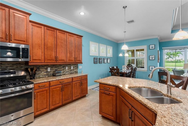 kitchen with decorative light fixtures, sink, appliances with stainless steel finishes, and ornamental molding