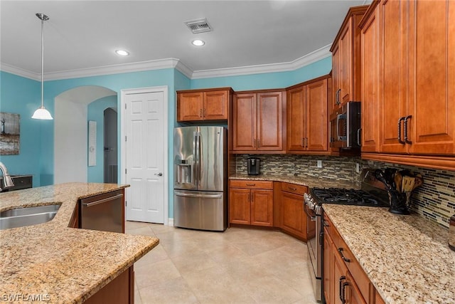 kitchen with backsplash, pendant lighting, sink, light stone countertops, and appliances with stainless steel finishes