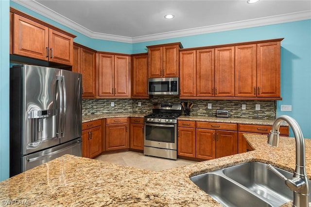 kitchen with stainless steel appliances, backsplash, light stone counters, and sink