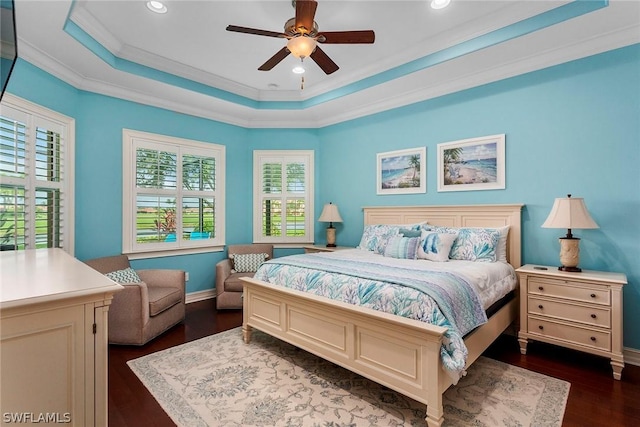 bedroom with ceiling fan, dark hardwood / wood-style floors, a tray ceiling, and ornamental molding