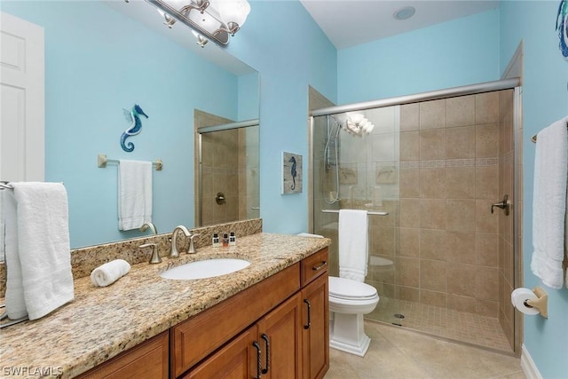 bathroom featuring toilet, vanity, a shower with door, and tile patterned floors