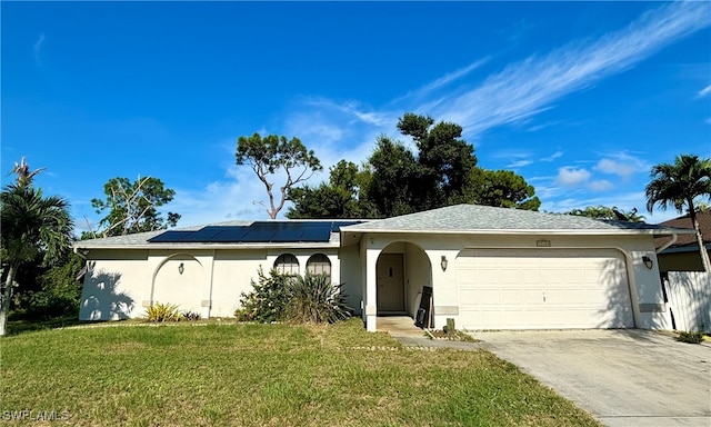 single story home with a garage, solar panels, and a front yard