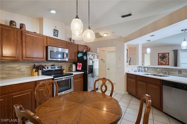 kitchen with pendant lighting, decorative backsplash, stainless steel appliances, and sink