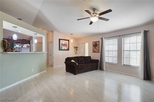 living room with light hardwood / wood-style flooring, lofted ceiling, and ceiling fan