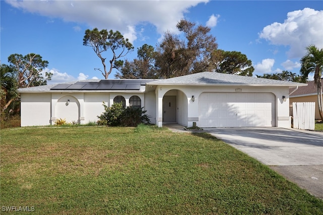 ranch-style home featuring a front lawn, a garage, and solar panels