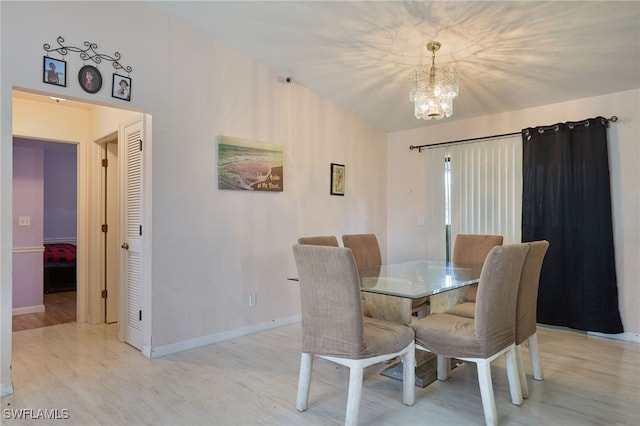 dining room with light hardwood / wood-style floors and a notable chandelier