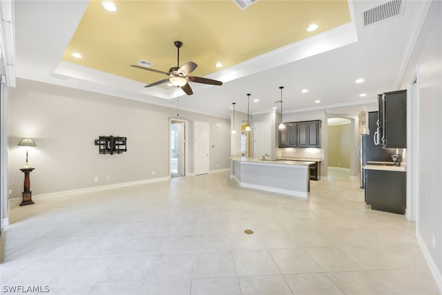 unfurnished living room featuring ornamental molding, a raised ceiling, visible vents, and a ceiling fan