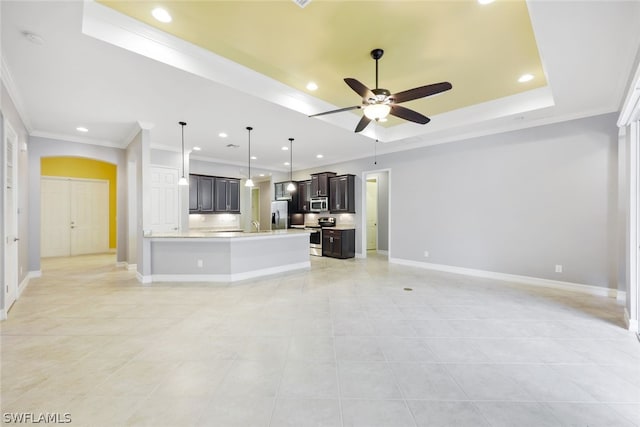 unfurnished living room featuring baseboards, ceiling fan, a tray ceiling, crown molding, and recessed lighting