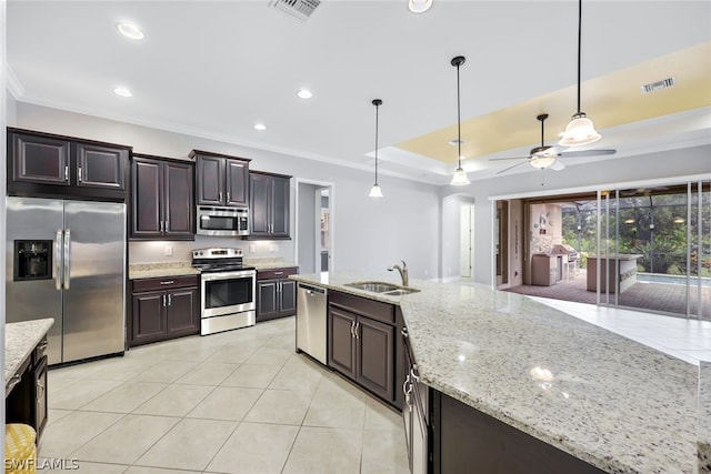 kitchen featuring visible vents, stainless steel appliances, a sink, and decorative light fixtures