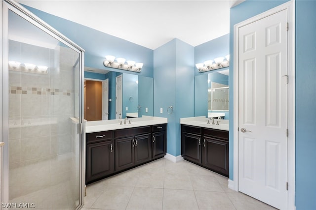 full bath featuring a sink, a stall shower, two vanities, and tile patterned floors