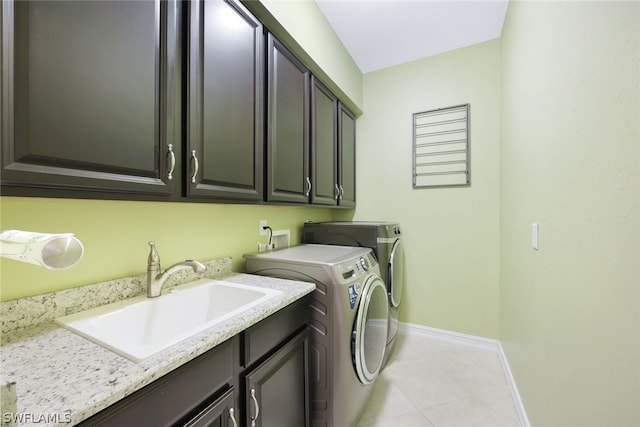 laundry room with cabinet space, baseboards, independent washer and dryer, a sink, and light tile patterned flooring