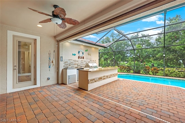 view of patio with an outdoor pool, an outdoor kitchen, a ceiling fan, grilling area, and outdoor wet bar