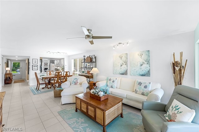 tiled living room with plenty of natural light and ceiling fan