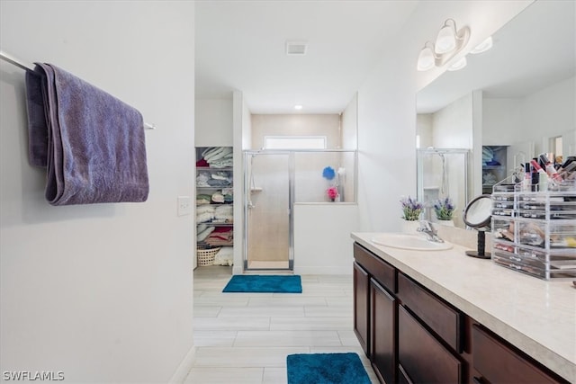 bathroom with a shower with door and vanity