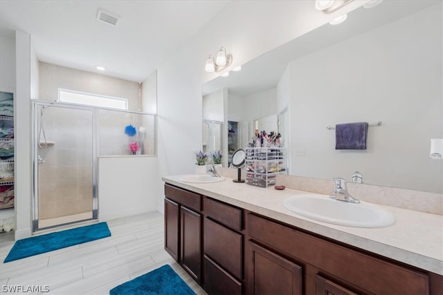 bathroom featuring a shower with shower door, tile patterned flooring, and double vanity