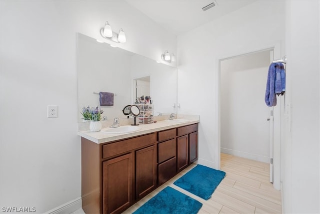 bathroom with double vanity and wood-type flooring