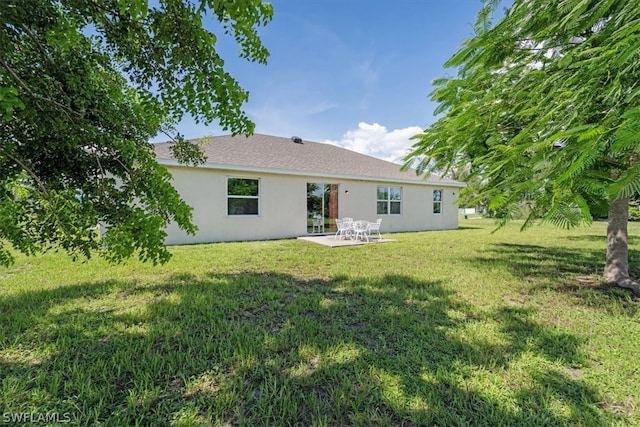 back of house with a patio area and a yard