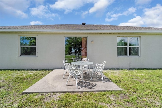 rear view of property featuring a yard and a patio area