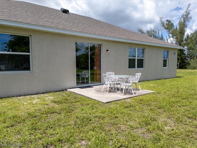 rear view of property featuring a patio and a yard