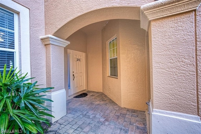 view of exterior entry featuring a patio area