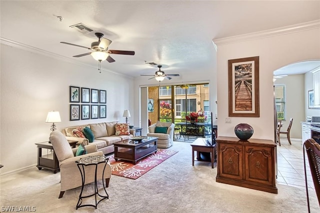 living room featuring ceiling fan, crown molding, and light colored carpet