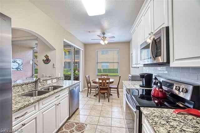 kitchen with decorative backsplash, sink, white cabinets, and stainless steel appliances