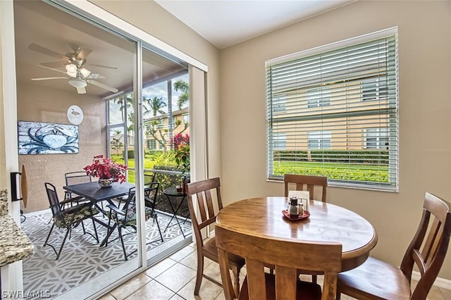 dining space with ceiling fan and light tile patterned flooring