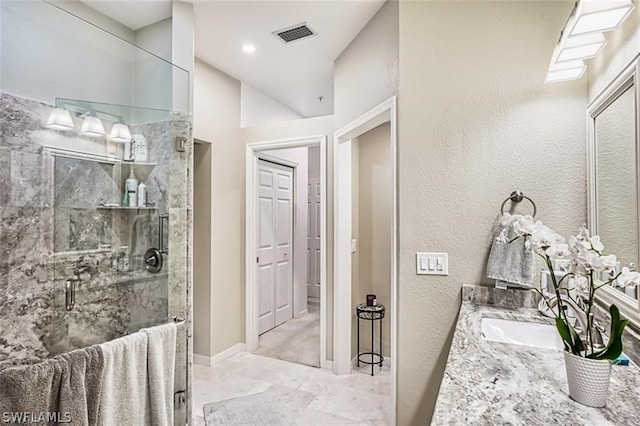 bathroom with a shower with shower door and vanity