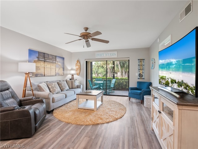 living room with light hardwood / wood-style flooring and ceiling fan