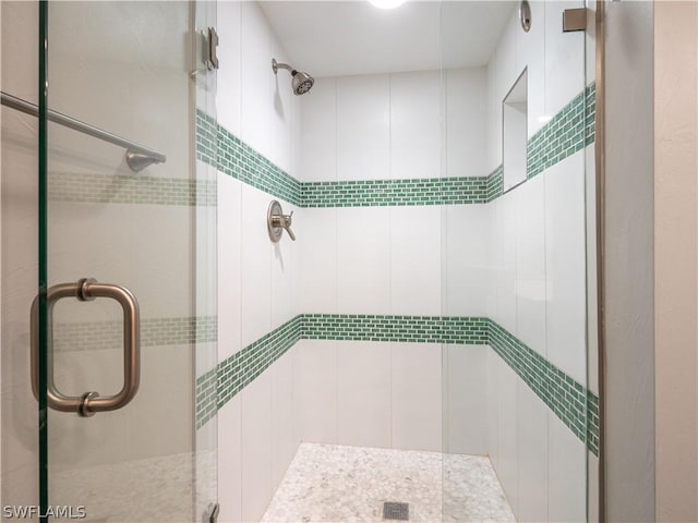 bathroom featuring a shower with door